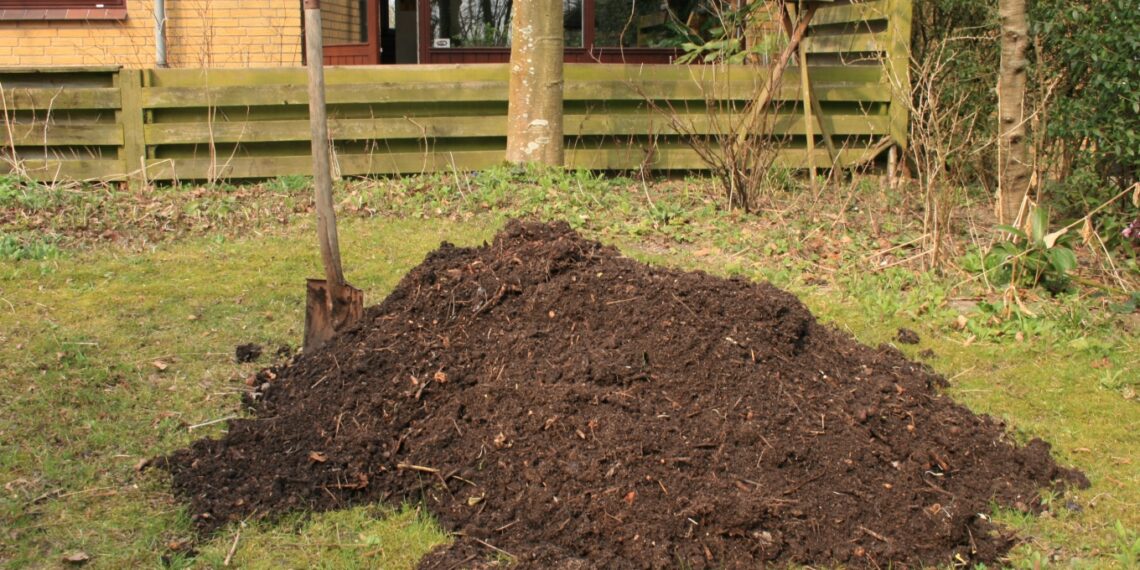 Tas de compost végétal dans un coin de jardin.