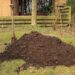 Tas de compost végétal dans un coin de jardin.